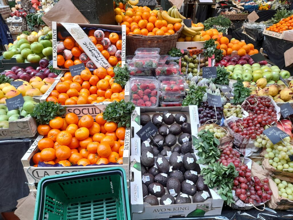 Vibrant display of fresh fruits and vegetables at a market stall in London.